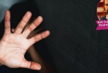 Open hand facing the camera in the foreground, blocking the face against a dark background; circular photo of a man in the top-right corner.