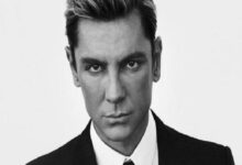 Black-and-white headshot of a man in a suit looking directly at the camera.