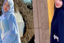 Two women wearing hijabs and long dresses posing side by side outdoors, one in light blue and the other in dark navy.