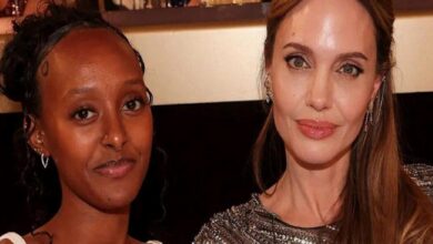 Two women posing for a close-up photo indoors; left woman has dark skin and a nose ring, right woman has long hair and a sparkly top.